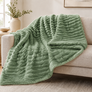 Green chunky ribbed plush blanket throw on a sofa