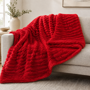 Red chunky ribbed plush blanket throw on a sofa