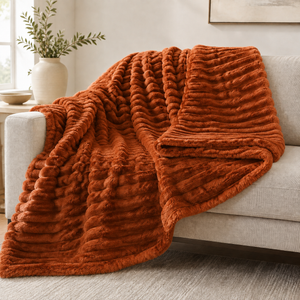 Rust chunky ribbed plush blanket throw on a sofa